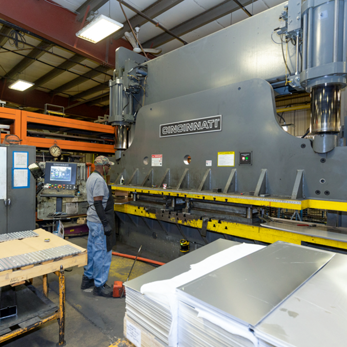 Worker using a press brake to showcase AROW's metal fabrication capabilities.